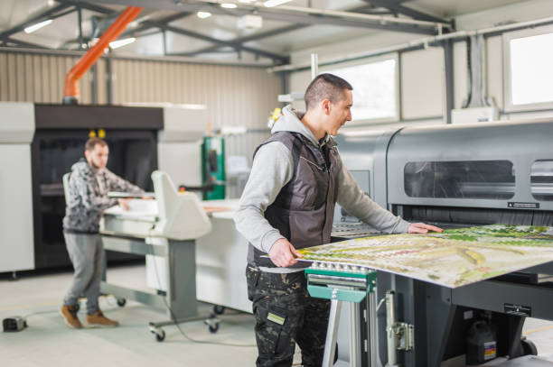 istock Technicians works in large printing press hall and printshop office 1216431109