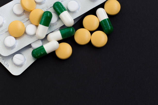 istock Pharmacy background on a black table. Tablets on a black background, pills. Medicine and healthy, close up of capsules. 1216432226