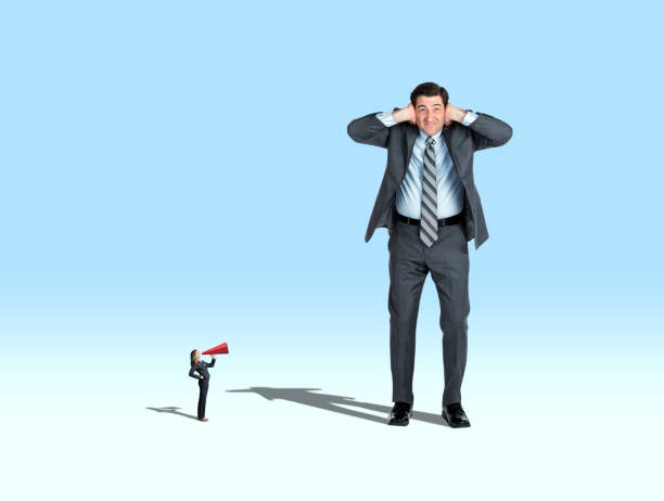 istock Woman Shouting At Large Man Through A Megaphone 1216432514