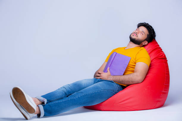 młodzi mężczyźni relaks na krześle worka fasoli na białym tle zdjęcie stockowe - sitting young men book isolated on white zdjęcia i obrazy z banku zdjęć