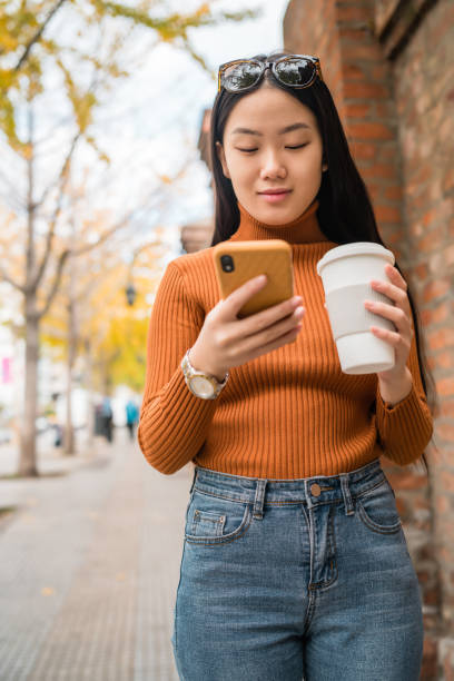 istock Asian woman using her mobile phone. 1216433593