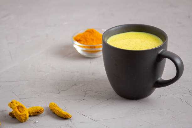 istock Golden milk in a dark gray cup on a gray background 1216433710