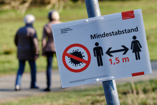 Sign telling pedestrians about 1.5m minimum distance because of the coronavirus Nuremberg, Germany - April 02, 2020: Sign telling pedestrians about 1,5 m Mindestabstand ( 1.5m minimum distance ) because of the coronavirus on a sunny and warm springtime day with two pedestrians franconia photos stock pictures, royalty-free photos & images