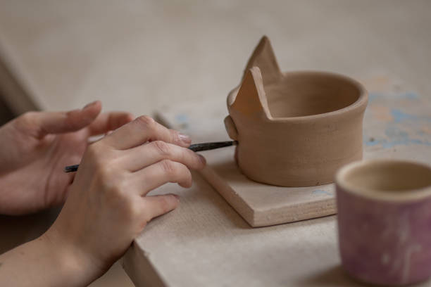 istock Workflow of a woman working behind a pottery wheel in an art workshop. Unknown master creates a jug. Focus only on the hands. Small business, talent, invention, inspiration concept. 1216435523