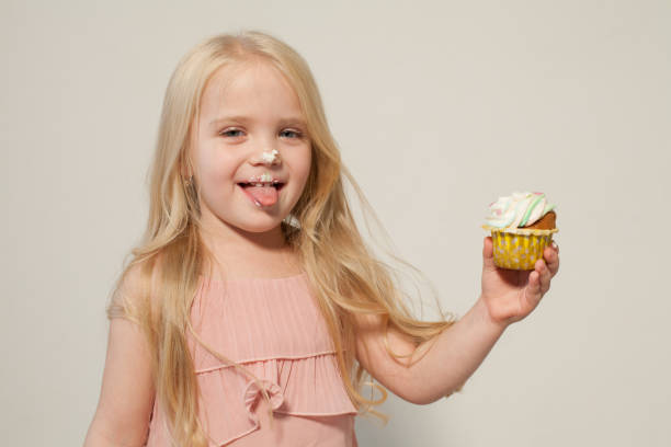 istock Little girl eats sweet cake with cream 1216435552