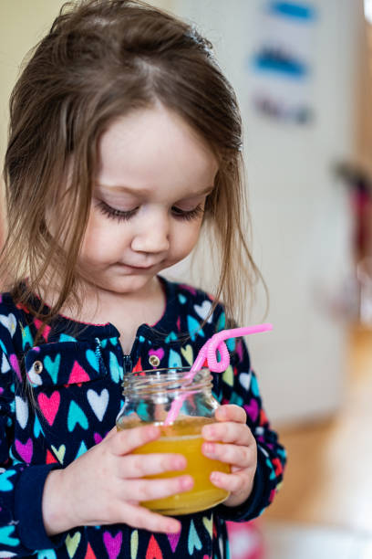 istock Girl Drinking Orange Juice 1216435657