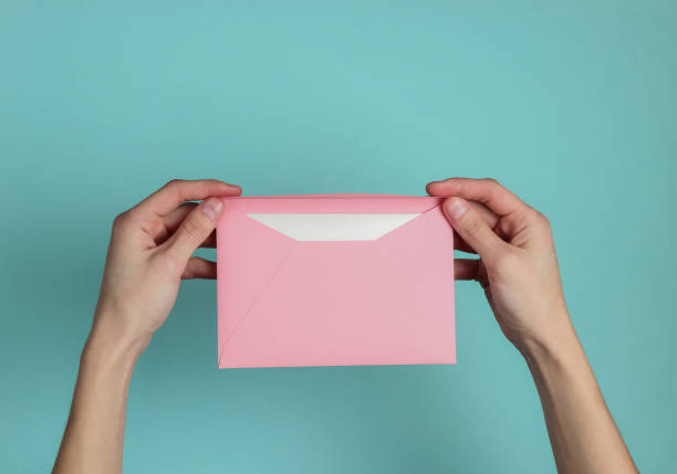 istock Female hand holds envelope with letter on blue pastel background. Top view. Valentine's day, wedding invitation, letter of love 1216436364