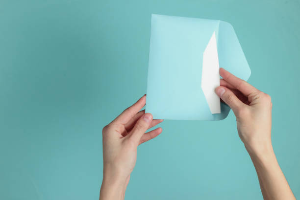istock Female hand holds envelope with letter on blue pastel background. Top view. Valentine's day, wedding invitation, letter of love 1216436372