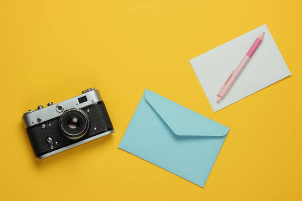 istock Envelope with letter, retro camera on yellow background. Top view. Travel concept 1216436574