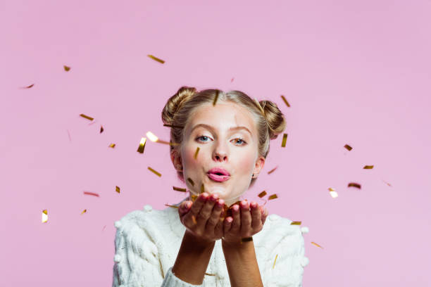 istock Beautiful teenege girl blowing confetti 1216437667