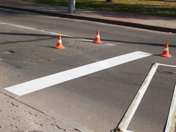 istock Road marking. Drawing a road marking. spraying in road construction. Worker draws a white line on the surface of the street 1216437737