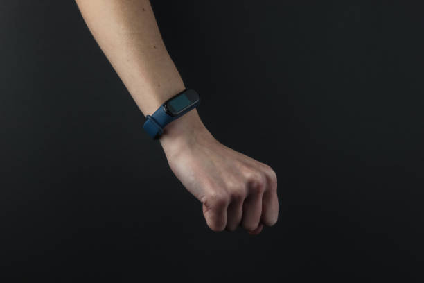 Female hand with a smart bracelet on a black background. Modern gadgets
