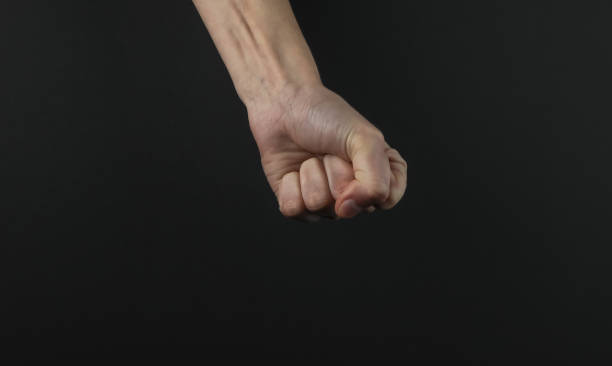 istock Female fist gesture on a black background 1216439506