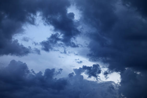 istock Blue sky with dark storm clouds at sunset 1216439771