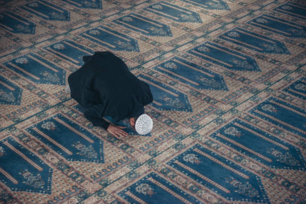 shot of a muslim young man worshiping in a mosque - islam praying mosque ramadan imagens e fotografias de stock