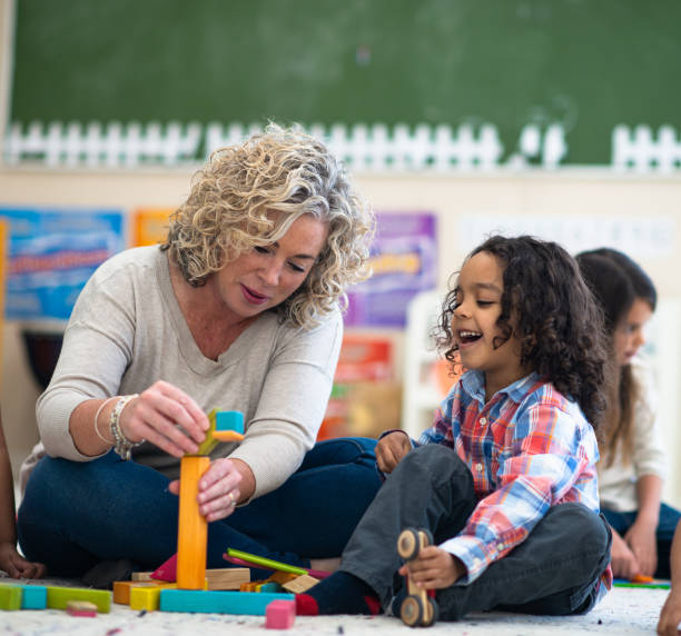 istock Kindergarten Teacher Helping Student Build stock photo 1216444507