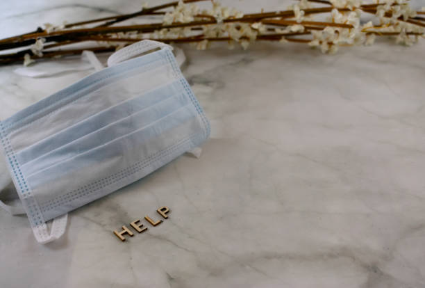 istock Surgical mask with help sign over marbled background with copy space 1216446328