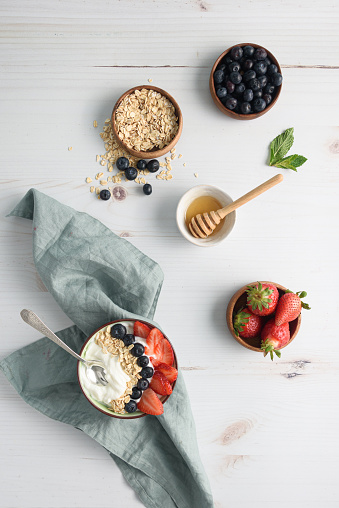 Bowl of yogurt with berries and oatmeal on table