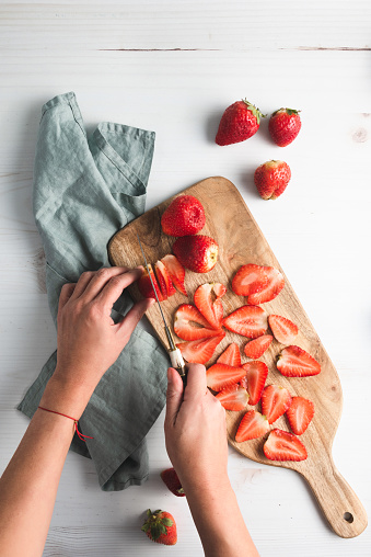Strawberries on cutting board, with knife and plate