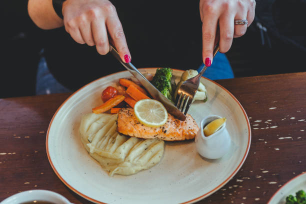 istock A woman eating redfish steak and mashed potatoes with vegetables 1216450952