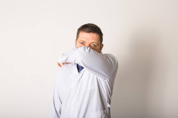 istock Young caucasian doctor coughing in elbow being ill 1216451029