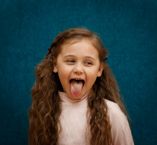 istock little girl shows tongue 1216452383