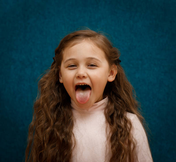 istock little girl shows tongue 1216452483