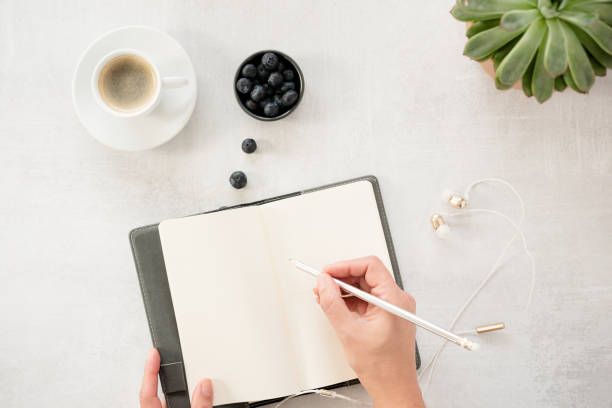 lay piatto di note book, caffè e donne mani scrittura - diary writing women human hand foto e immagini stock