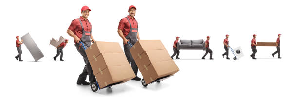 istock Movers carrying furniture and boxes on hand-trucks 1216453726