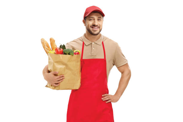 istock Man in a uniform holding a paper bag with food 1216453886