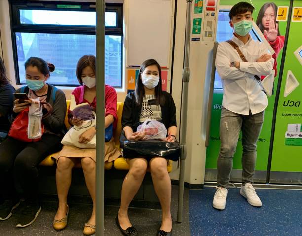 pasajeros que usan máscaras faciales en el tren aéreo bts - bangkok mass transit system fotografías e imágenes de stock