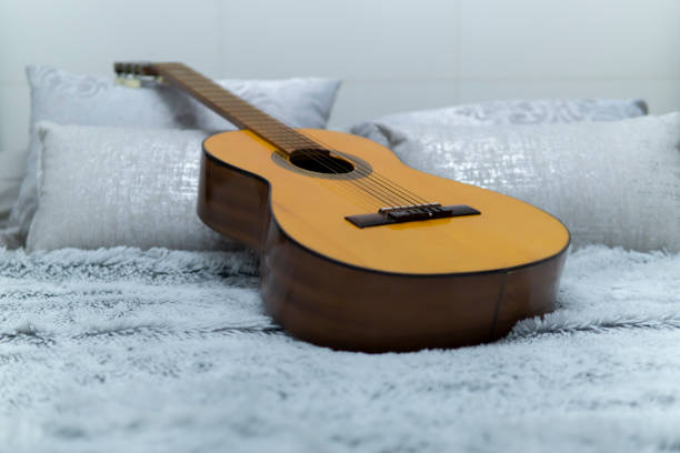 istock Spanish guitar on white bed 1216453999