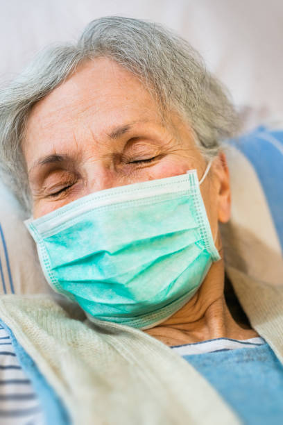 istock old woman lying in bed with a face mask 1216456906
