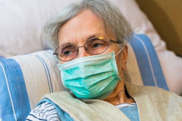 istock elderly woman lying in bed with a face mask 1216456910