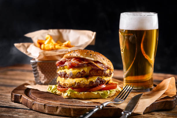 set di hamburger e patatine fritte. un set standard di bevande e cibo nel pub, birra e snack. sfondo scuro, fast food. cibo tradizionale americano - american cuisine foto e immagini stock