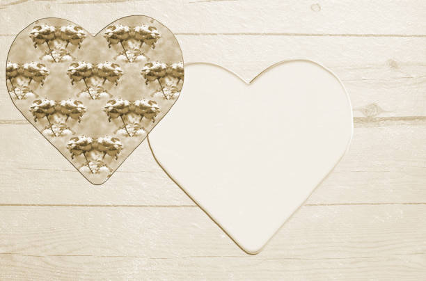 Two stylized hearts on a textured wooden background. Sepia tinted. Concept of love