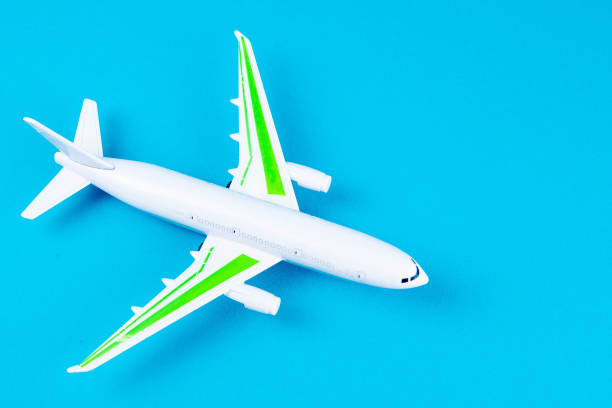istock white airplane on a blue background, top view 1216459902