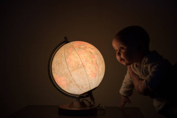istock New born baby looking at the globe 1216461113