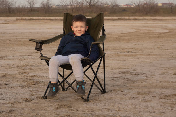 istock A 4-year-old boy sits on a folding chair on an empty beach during quarantine. 1216462165