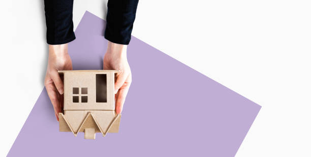 istock Woman holding a cardboard house 1216462457