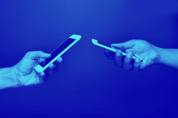 istock Two Hands Holding Mobile Phones 1216462741