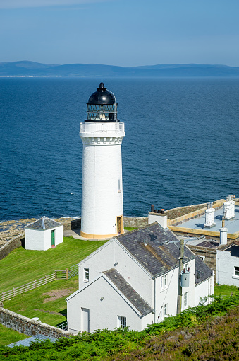 Davaar island white lighthouse and cottadges vertical photo. Campbeltown, Scotland