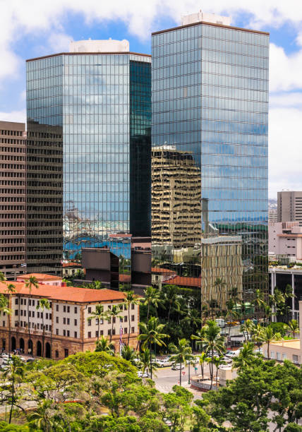 High rise apartment buildings are reflected in the mirror like surface of twin office buildings in downtown Honolulu, Hawaii