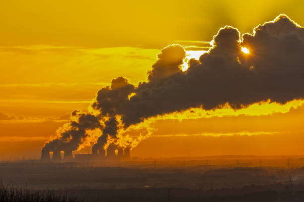 odległy widok na szlak pary wodnej z wież chłodniczych elektrowni w pobliżu drax, north yorkshire.  obraz z podświetlenia o zachodzie słońca. - industry dusk night sustainable resources zdjęcia i obrazy z banku zdjęć