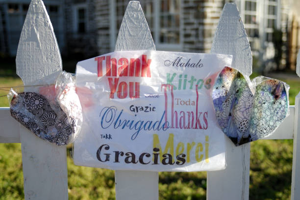 Philadelphia, PA, USA - April 2, 2020; Messages in support of essential personal, written on hearts and wrapped in plastic, hang from a white picked fence in the Mt Airy neighborhood of Philadelphia, PA, on April 2, 2020.