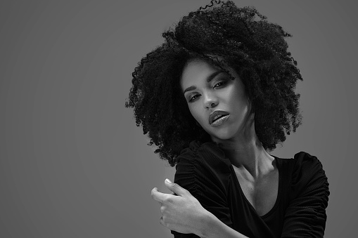 Beautiful african american woman looking at camera. Portrait of cheerful young woman with afro hairstyle. Beauty girl with curly hair.