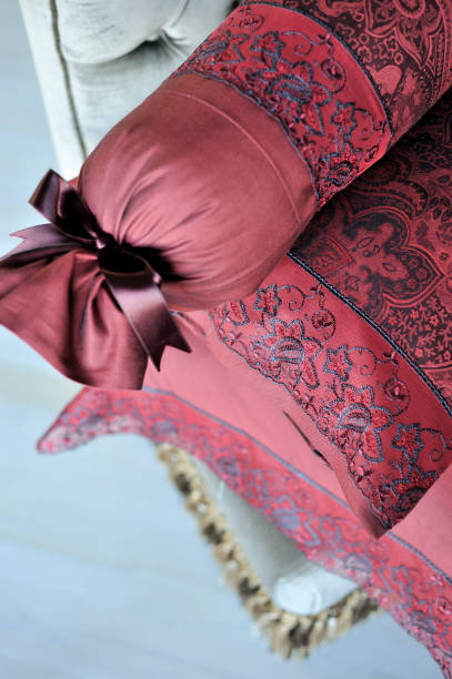 Detail of the sheet set in Indian red - 2 Close-up shooting of a sheet set in Indian red, with pillows and a bolster red cushion covers stock pictures, royalty-free photos & images