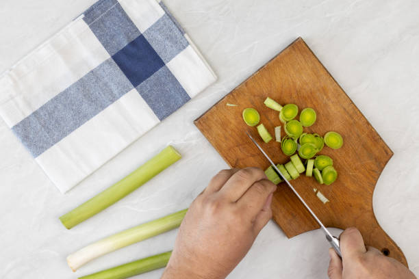 istock Cutting leak vegetable on the wooden board above grey marble table 1216481205