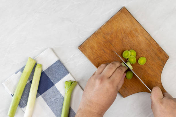 istock Cutting leak vegetable on the wooden board above grey marble table 1216481283