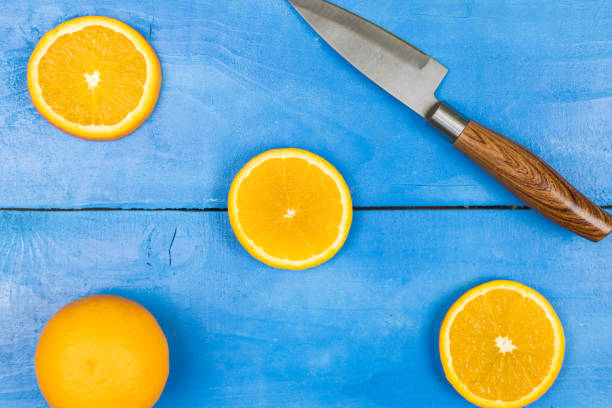 Flatlay above sliced orange on the blue wooden table.